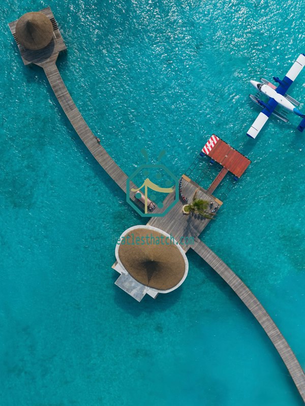 Aerial view of Maldives overwater villas with synthetic thatch roofing #